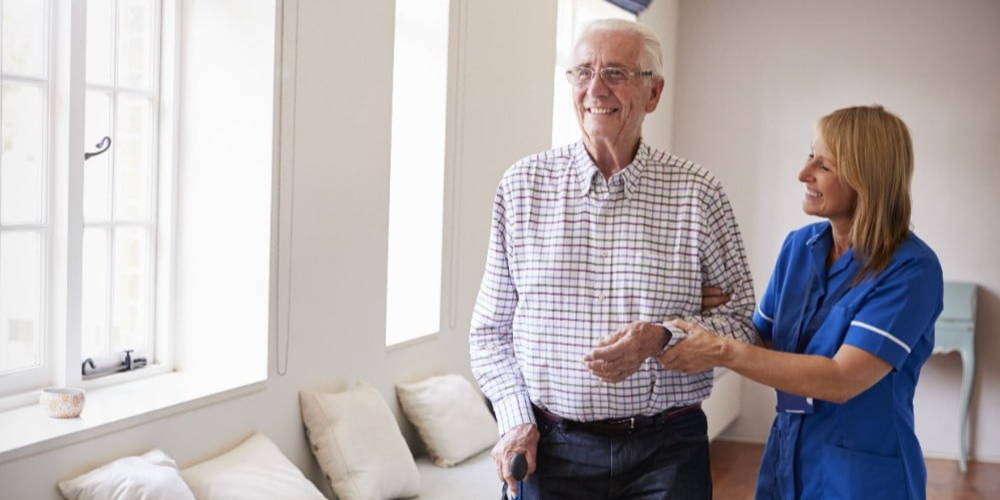 Physiotherapist helping elderly man who has Parkinson's disease